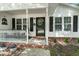 Close-up of the inviting front porch, complete with a decorative door, black shutters, and stone-accented landscaping at 1306 Markley Ct, Moncks Corner, SC 29461