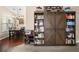 Living room view of a large bookshelf with sliding doors, a dining area with chandelier, and beautiful wood flooring at 1306 Markley Ct, Moncks Corner, SC 29461