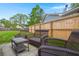A quaint outdoor seating area with dark brown wicker furniture that includes chairs and a bench surrounding a glass table at 1306 Markley Ct, Moncks Corner, SC 29461