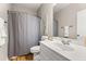 Well-lit bathroom with a white sink, toilet, mirror, and shower with a grey curtain at 135 Marshside Dr, Summerville, SC 29485