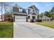 Attractive two-story home with a double garage, manicured front yard, and a long driveway at 135 Marshside Dr, Summerville, SC 29485