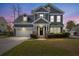 Charming two-story home with a well-manicured lawn, a welcoming front porch, and an attached two-car garage at 135 Marshside Dr, Summerville, SC 29485