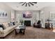 Comfortable living room with a fireplace, large windows, and a ceiling fan at 135 Marshside Dr, Summerville, SC 29485
