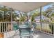 Screened porch with white railings showcasing a metal table and chairs with colorful cushions at 135 Marshside Dr, Summerville, SC 29485