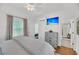 Airy bedroom featuring hardwood floors, TV, white walls, ensuite bathroom, and two bright windows at 1466 Mizzen Aly, Johns Island, SC 29455