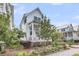 Charming white home with teal shutters and inviting front porch complemented by lush greenery and landscaping at 1466 Mizzen Aly, Johns Island, SC 29455