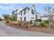 Beautiful white home showcasing teal shutters and well-kept landscaping with ornamental grasses and plants at 1466 Mizzen Aly, Johns Island, SC 29455