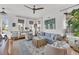 Bright and airy living room with a blue sofa, white chairs, and a ceiling fan at 1466 Mizzen Aly, Johns Island, SC 29455