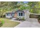 Charming home with light-gray siding, white brick, and a bright orange front door surrounded by lush greenery at 1531 Seacroft Rd, James Island, SC 29412