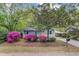 View of charming home featuring beautiful azaleas, light-gray siding, orange door, and covered parking area at 1531 Seacroft Rd, James Island, SC 29412