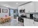 Kitchen with dining area featuring white cabinets, stainless appliances, tile backsplash and flooring at 1531 Seacroft Rd, James Island, SC 29412
