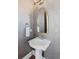 Stylish powder room featuring a pedestal sink, decorative mirror, and unique textured wallpaper at 1555 Willtown St, Daniel Island, SC 29492