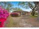 Charming brick home with a cozy front porch and vibrant landscaping under mature trees at 1673 Mcclain St, Charleston, SC 29407