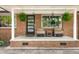 Cozy front porch with comfortable seating, hanging ferns, and a charming brick facade at 1673 Mcclain St, Charleston, SC 29407