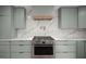 Beautiful kitchen featuring an oven range, sleek light green cabinets, and hardwood flooring at 1673 Mcclain St, Charleston, SC 29407