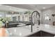Open-concept kitchen with a large island, sink, and stainless steel faucet with a view into the light-filled living room at 1673 Mcclain St, Charleston, SC 29407