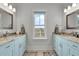 Symmetrical bathroom with dual sinks, marble countertops, and matching mirrors, offering luxury and functionality at 1857 W Canning Dr, Mount Pleasant, SC 29466