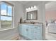 Light and bright bathroom featuring a large vanity, marble countertop, modern fixtures, and view to the outside at 1857 W Canning Dr, Mount Pleasant, SC 29466