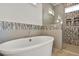 Modern bathroom with a freestanding tub and separate glass-enclosed shower with decorative tiles at 1857 W Canning Dr, Mount Pleasant, SC 29466