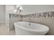 Elegant bathtub in modern bathroom featuring decorative tiled wall and lighting at 1857 W Canning Dr, Mount Pleasant, SC 29466
