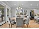 Elegant dining area with large windows, chandelier lighting, and seating for six with hardwood floors at 1857 W Canning Dr, Mount Pleasant, SC 29466