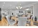 Bright dining room is open to the kitchen, featuring a stylish chandelier and six upholstered chairs at 1857 W Canning Dr, Mount Pleasant, SC 29466