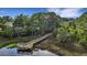 Aerial view of a wooden dock extending into a marshy waterway surrounded by lush greenery at 1857 W Canning Dr, Mount Pleasant, SC 29466