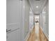 Hallway featuring hardwood floors, white trim, and multiple doors leading to different rooms in the home at 1857 W Canning Dr, Mount Pleasant, SC 29466