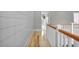 Hallway with hardwood floors, shiplap walls, and white trim leads to various rooms at 1857 W Canning Dr, Mount Pleasant, SC 29466