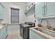 Updated laundry room features blue cabinets, granite countertops, stainless steel appliances, and a window at 1857 W Canning Dr, Mount Pleasant, SC 29466