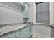 Bright laundry room has gray countertops, custom blue cabinets, and a convenient hanging rod at 1857 W Canning Dr, Mount Pleasant, SC 29466