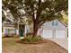 Charming two-story home with light gray siding, blue shutters, manicured lawn, and a mature shade tree in front at 2000 Gray Battery Court Ct, Mount Pleasant, SC 29464