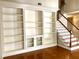 Spacious living room showcasing built-in shelving, hardwood flooring, and an adjacent staircase with white railings at 2000 Gray Battery Court Ct, Mount Pleasant, SC 29464