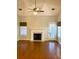 Bright living room showcasing a fireplace with white mantle, fan and lighting, and glossy hardwood flooring at 2000 Gray Battery Court Ct, Mount Pleasant, SC 29464