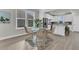 Dining area with wicker chairs adjacent to a modern, well-lit kitchen at 202 Garden Gate Way, Summerville, SC 29486