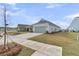 Exterior view featuring lush yard, long driveway, and a two-car garage at 202 Garden Gate Way, Summerville, SC 29486