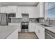 Well-equipped kitchen with sleek white cabinets, stainless appliances, and ample counter space at 202 Garden Gate Way, Summerville, SC 29486