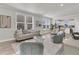 Open-concept living area with large windows, comfortable seating, and adjacent dining space at 202 Garden Gate Way, Summerville, SC 29486