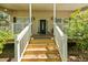 Charming front porch with white railings, flower pots, and a decorative front door at 213 Travelers Rest Blvd, Summerville, SC 29485