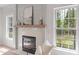 Close up of the fireplace, a bright window, and some neutral paint, that add charm to the house's living room area at 2226 Red Fern Lane, Mount Pleasant, SC 29466