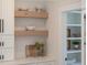 Modern kitchen features floating shelves with decor, white subway tile, countertop, and pantry at 2226 Red Fern Lane, Mount Pleasant, SC 29466