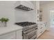 Modern kitchen with stainless steel stove and hood, white subway tile backsplash, and quartz countertops at 2226 Red Fern Lane, Mount Pleasant, SC 29466