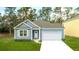 Charming one-story home with blue siding, white trim, and a well-manicured front lawn, perfect for first-time buyers at 2243 Macallan Blvd, Ravenel, SC 29470