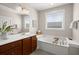 Well-lit bathroom featuring a soaking tub, double vanity, and large mirrors at 2519 Rutherford Way, Charleston, SC 29414