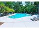 Community pool with many lounge chairs and umbrellas with mature trees in the background at 2519 Rutherford Way, Charleston, SC 29414