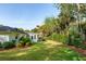 Expansive, green backyard with lush landscaping surrounds this home, with a sunroom and brick exterior at 3 Lauden Blvd, Isle of Palms, SC 29451
