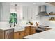 Close-up of a modern kitchen featuring a white quartz countertop, stainless steel appliances, and floating shelves at 3 Lauden Blvd, Isle of Palms, SC 29451