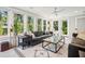 Sunlit living room with large windows, a comfortable leather sofa, and a decorative rug at 3 Lauden Blvd, Isle of Palms, SC 29451