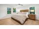 Comfortable main bedroom with hard wood floors, modern ceiling fan, and windows overlooking the front yard at 3 Lauden Blvd, Isle of Palms, SC 29451