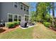Landscaped backyard with a stone patio, grill, and beautiful green lawn at 3010 Emma Ln, Mount Pleasant, SC 29466